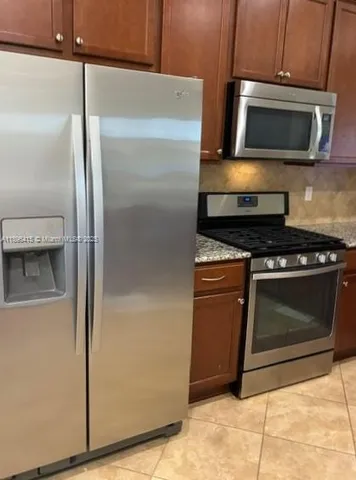a kitchen with a refrigerator stove and microwave