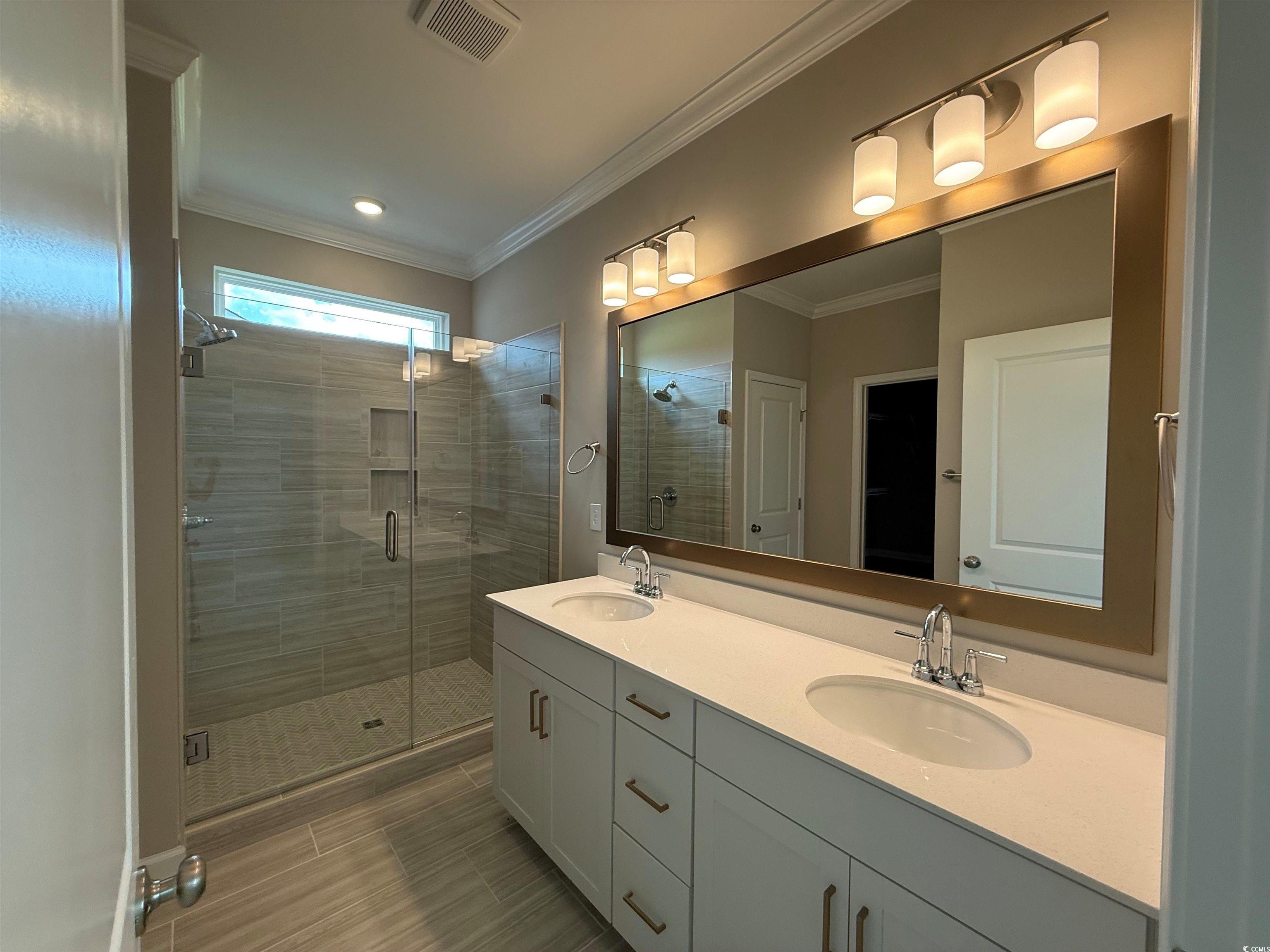 4040 Bucolic Loop Myrtle Beach, SC 29588 - Photo 5 of 13 Bathroom with a stall shower, double vanity, crown