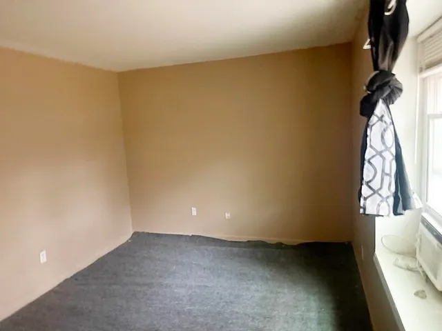 an empty room with windows and closet