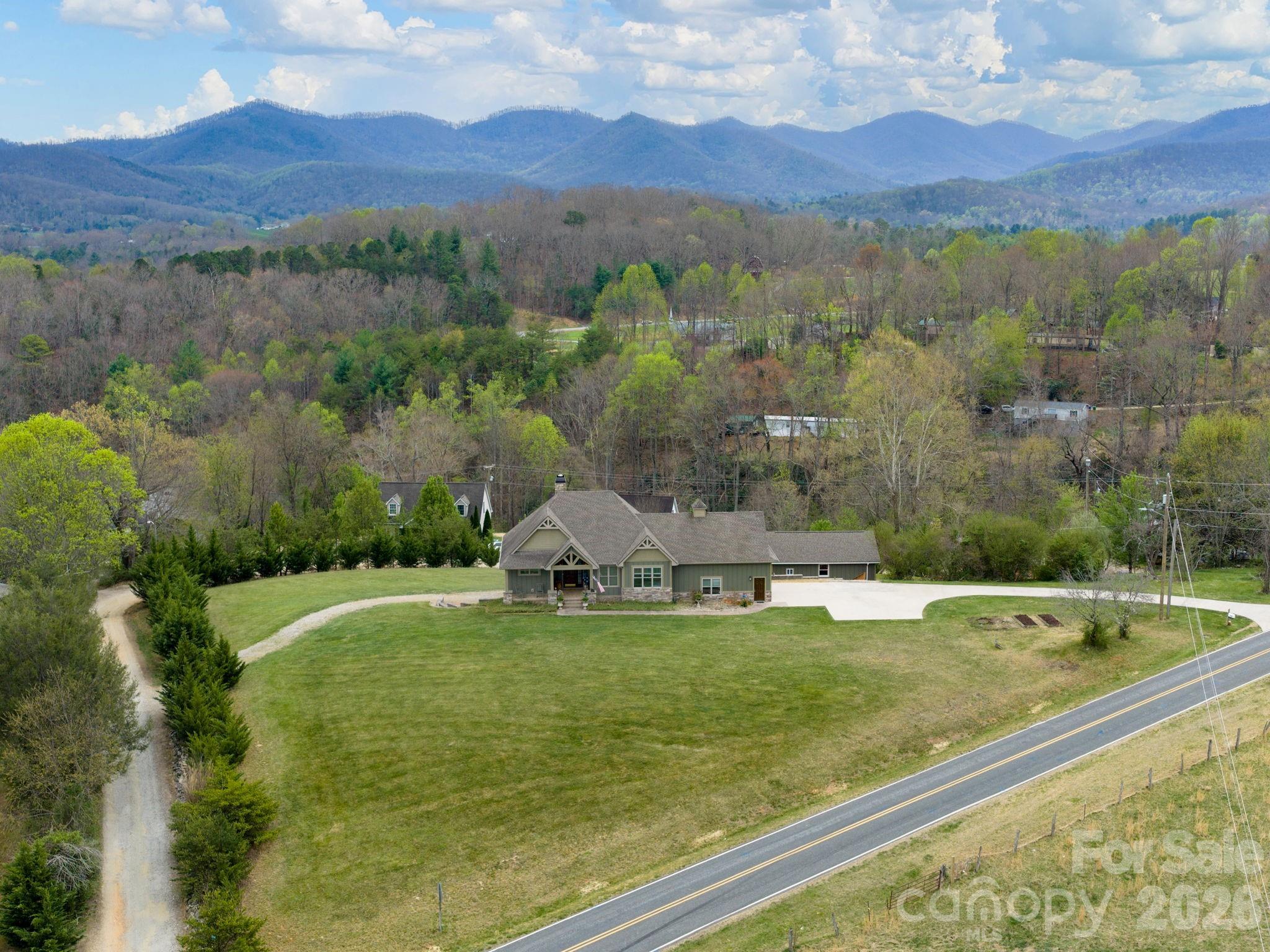 193 Youngs Cove Road Candler, NC 28715 - Photo 4 of 48 a view of a lush green hillside and houses