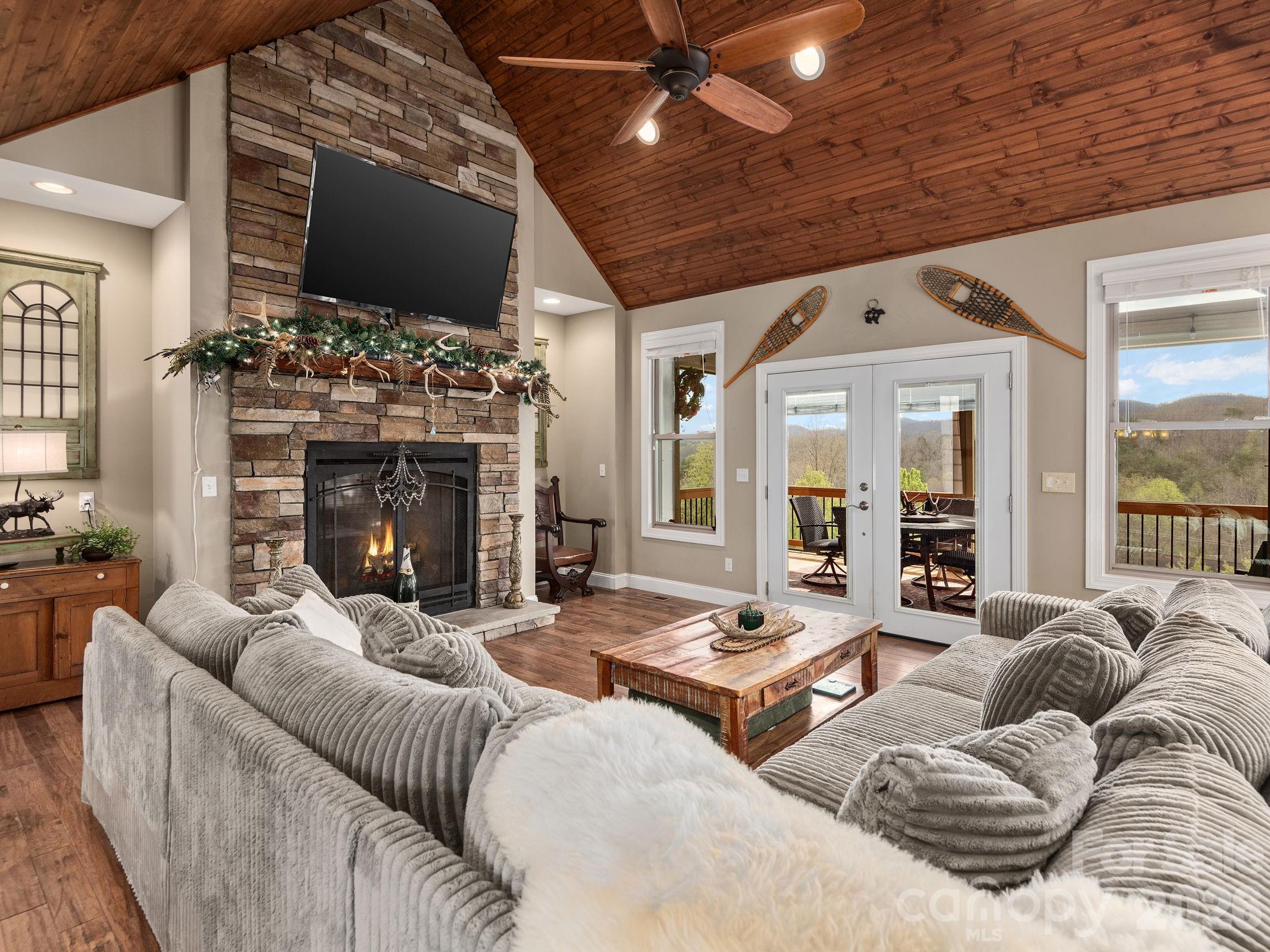 193 Youngs Cove Road Candler, NC 28715 - Photo 7 of 48 a living room with furniture a fireplace and a flat screen tv