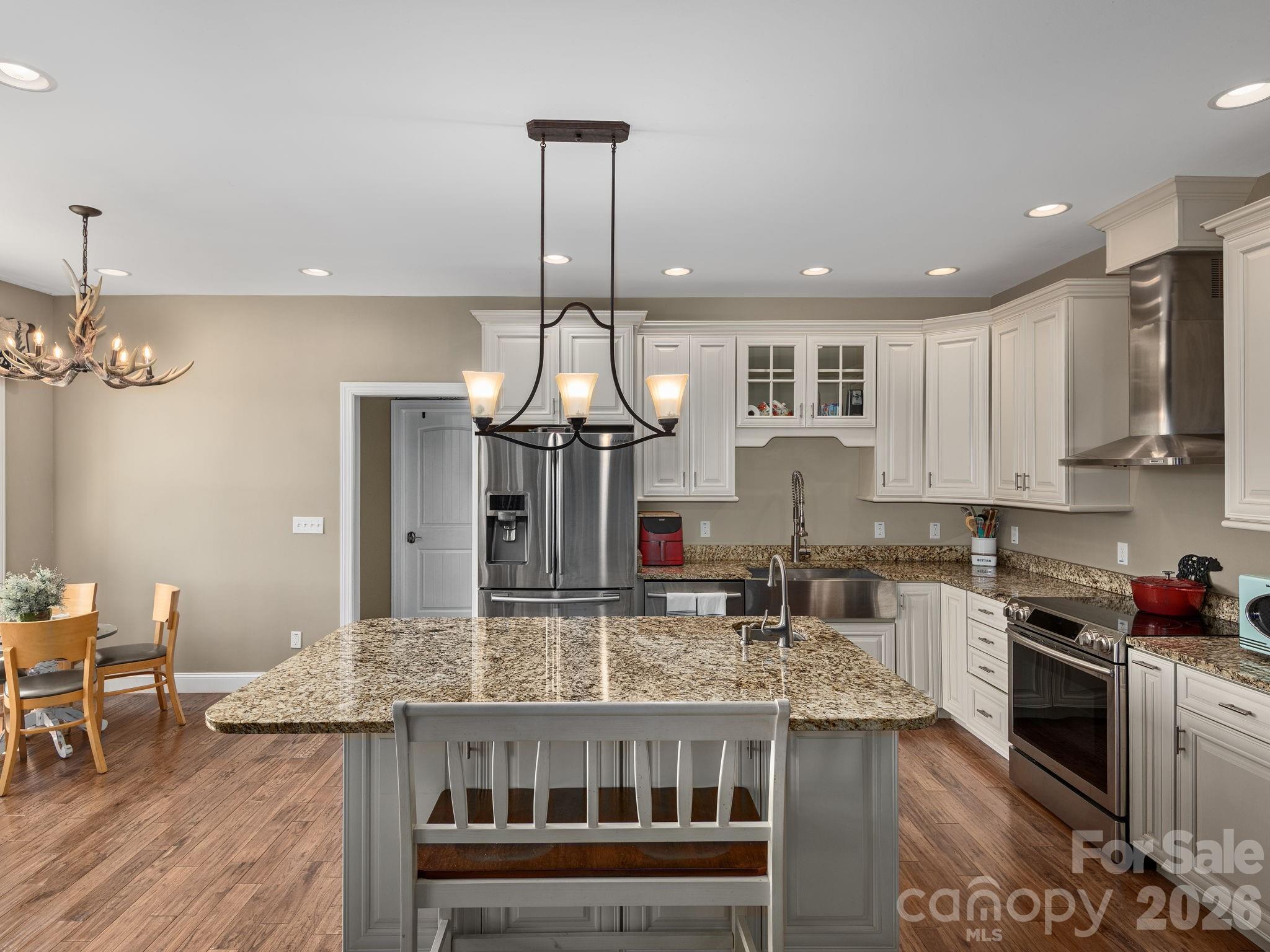 193 Youngs Cove Road Candler, NC 28715 - Photo 9 of 48 a kitchen with stainless steel appliances granite countertop a kitchen island a stove a table and chairs in it