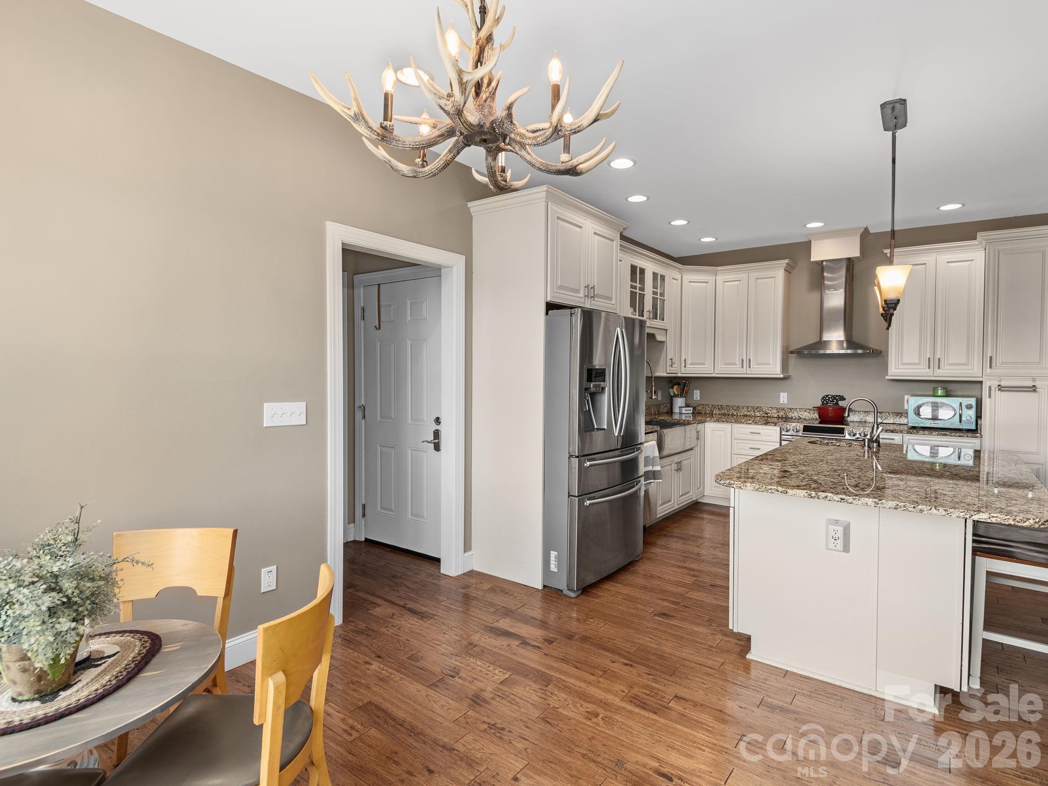 193 Youngs Cove Road Candler, NC 28715 - Photo 10 of 48 a kitchen with stainless steel appliances granite countertop a refrigerator a sink dishwasher a stove and white cabinets with wooden floor