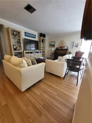 a living room with furniture a wooden floor and a large window