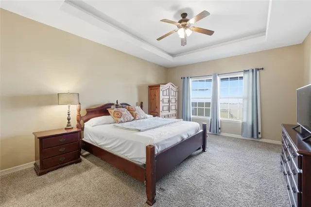 a spacious bedroom with a bed and a chandelier