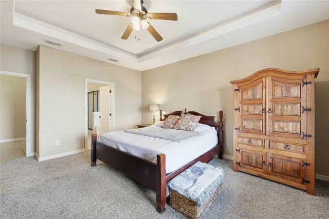 a bedroom with a bed a dresser and a chandelier