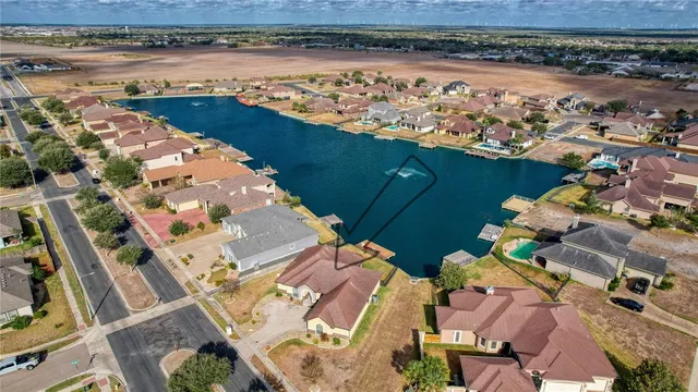 an aerial view of ocean and residential houses with outdoor space