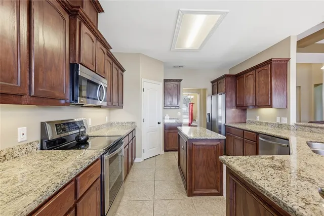 a kitchen with stainless steel appliances granite countertop a sink stove and refrigerator