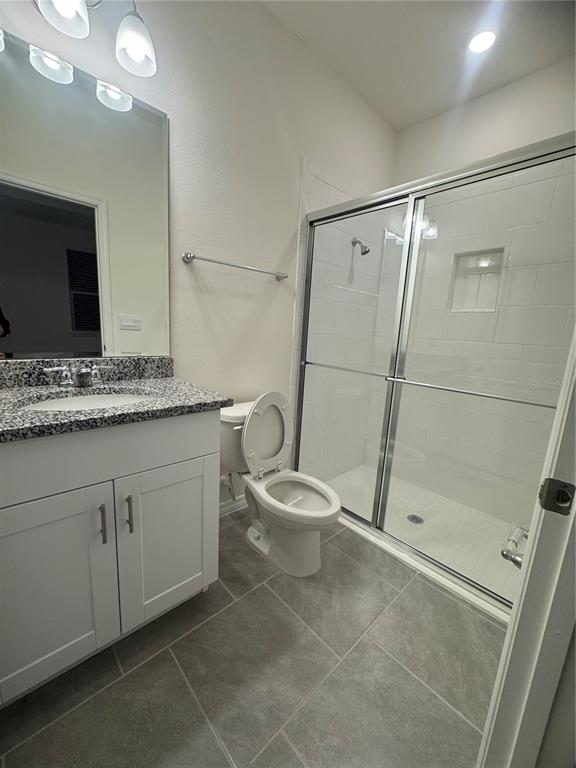 1729 Bull Hill Road Kissimmee, FL 34744 - Photo 17 of 34 a bathroom with a granite countertop sink toilet and shower