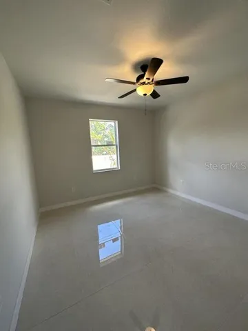 an empty room with windows and fan