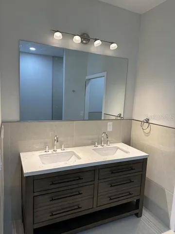 a bathroom with a double vanity sink and a mirror
