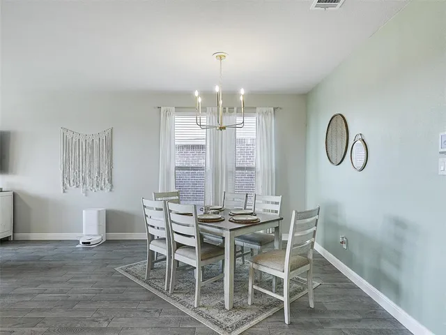 a dining room with furniture a chandelier and wooden floor