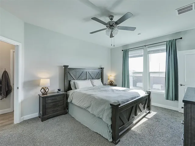 a bedroom with a bed a window and a chandelier