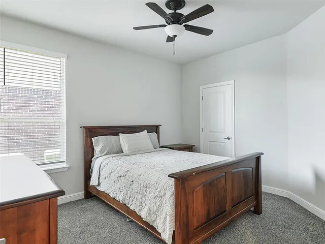 a bedroom with a bed chandelier and a window