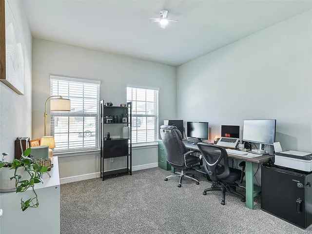 a view of a workspace with furniture and a window