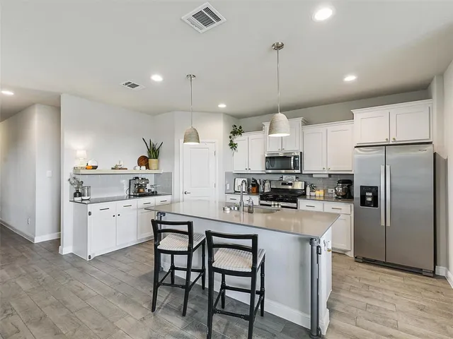 a kitchen with kitchen island granite countertop a counter space stainless steel appliances and cabinets