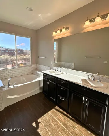 a spacious bathroom with a tub double sink and a mirror