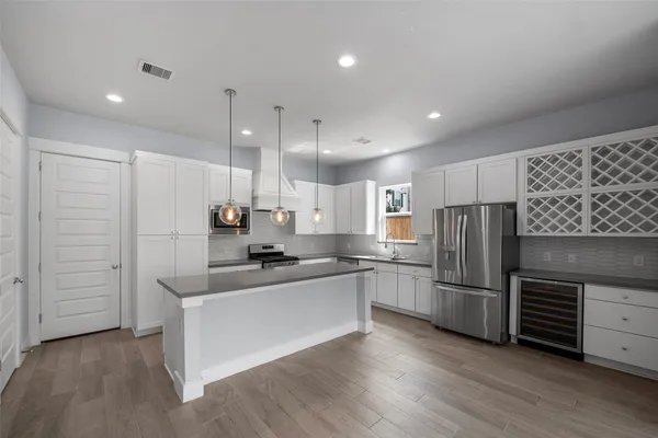 a kitchen with stainless steel appliances granite countertop white cabinets and stove