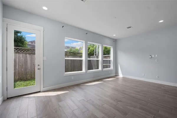 a view of an empty room with a kitchen and windows