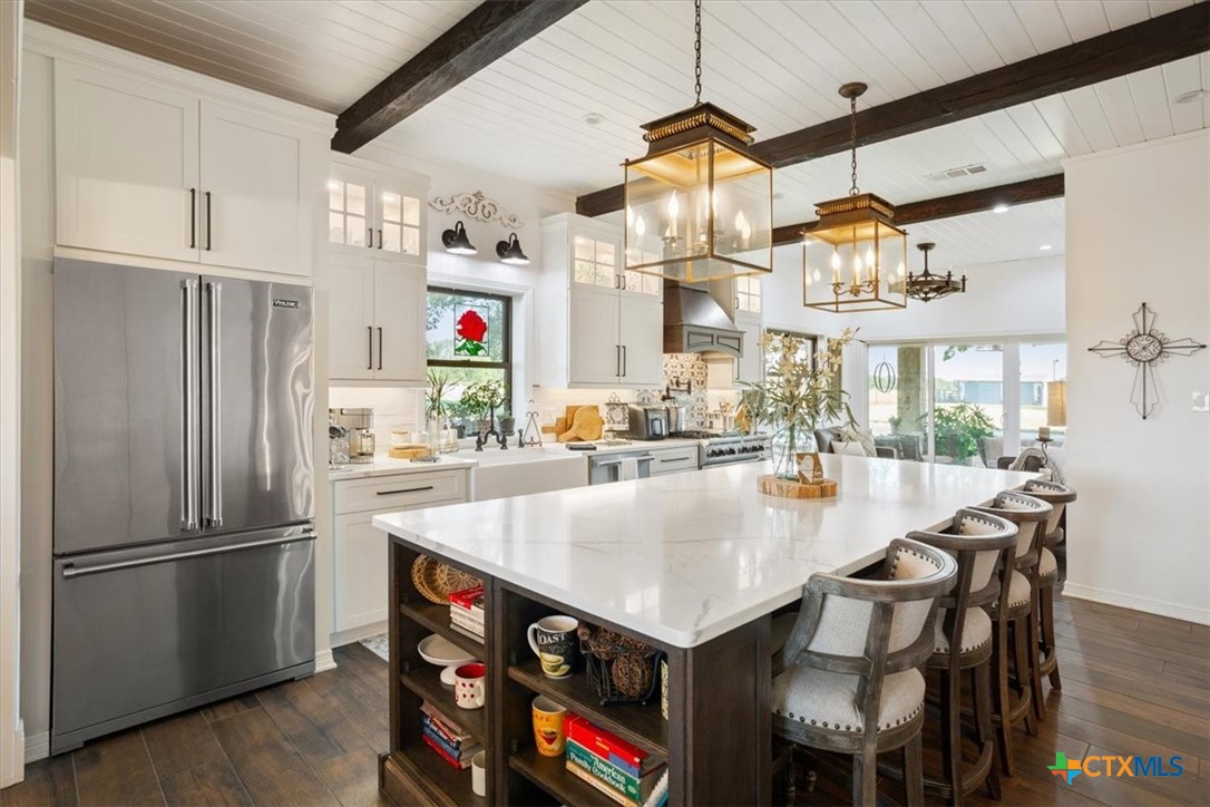 6409 3 Forks Road Belton, TX 76513 - Photo 20 of 40 a kitchen with stainless steel appliances granite countertop a refrigerator a stove and a dining table with wooden floor