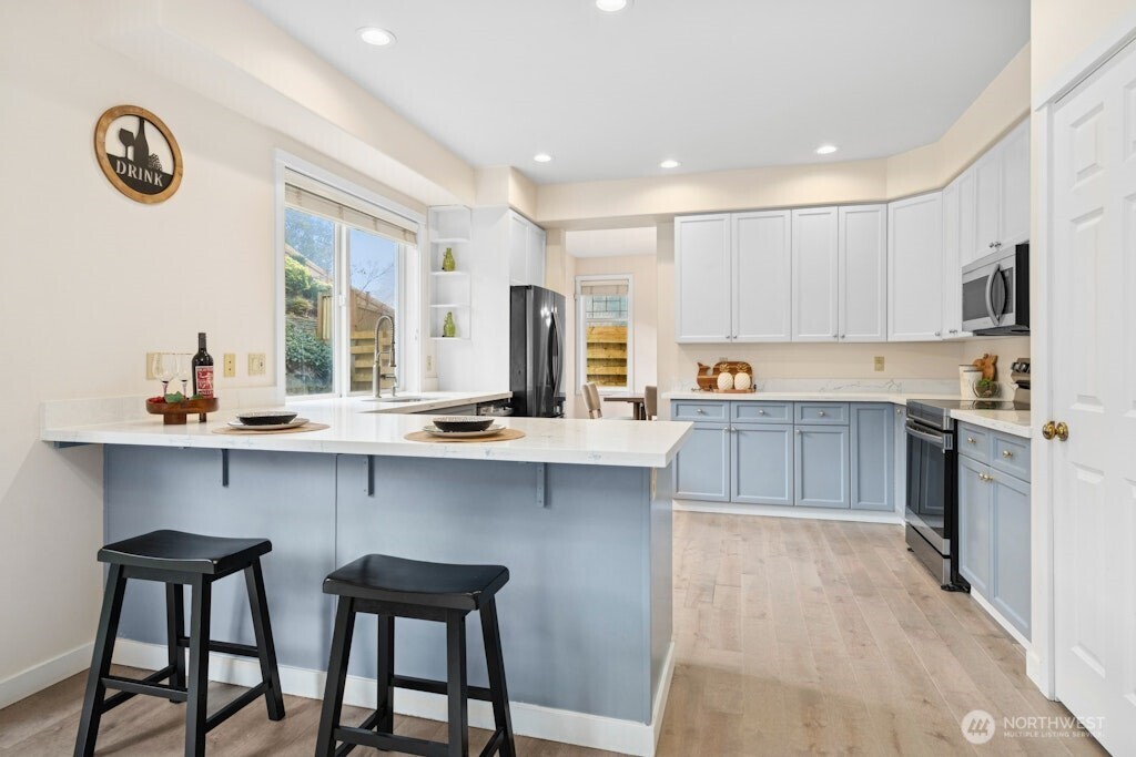 1807 Northeast 26th Place Renton, WA 98056 - Photo 14 of 38 a kitchen with table chairs cabinets and wooden floor
