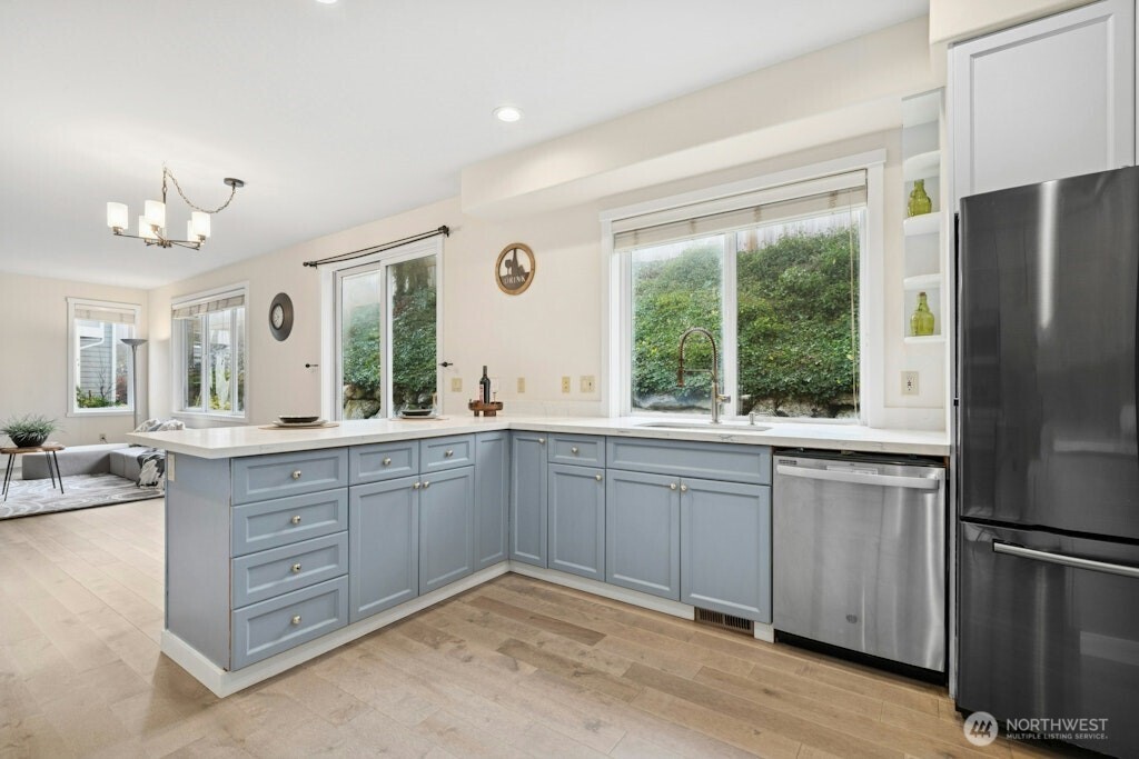 1807 Northeast 26th Place Renton, WA 98056 - Photo 15 of 38 a large kitchen with a window wooden floor and stainless steel appliances