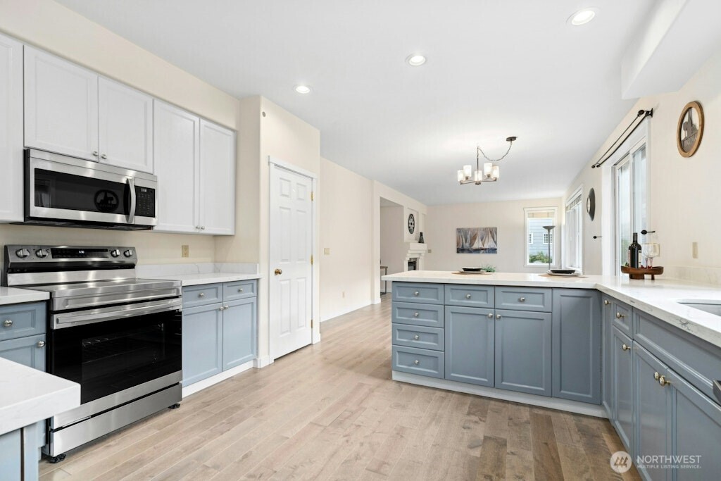 1807 Northeast 26th Place Renton, WA 98056 - Photo 17 of 38 a large kitchen with stainless steel appliances granite countertop a stove and a sink
