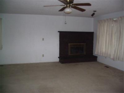 241 Liberty Road Granger, WA 98932 - Photo 3 of 6 an empty room with a fireplace and fan