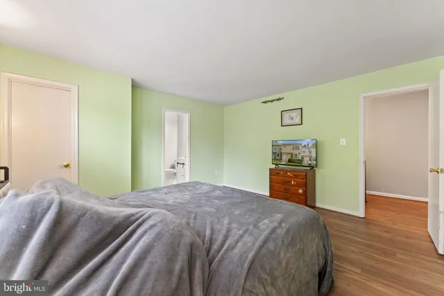 a bedroom with a large bed and a wooden floor