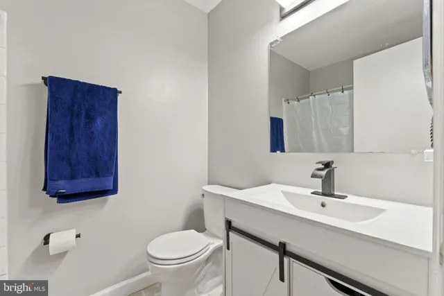 a bathroom with a toilet a sink and mirror