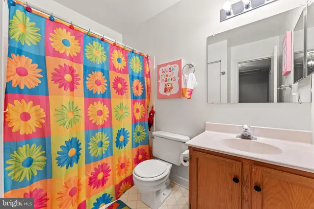 a bathroom with a sink toilet and shower curtain