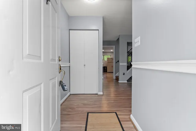 a hallway with wooden floor fireplace and living room