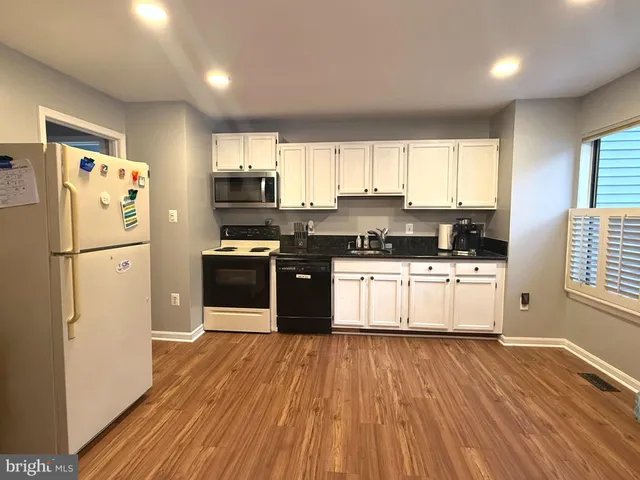 a kitchen with a refrigerator and a stove top oven
