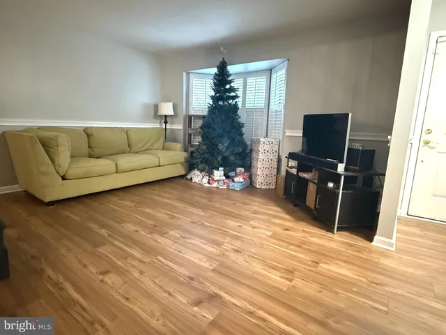 a living room with furniture a flat screen tv and a floor to ceiling window