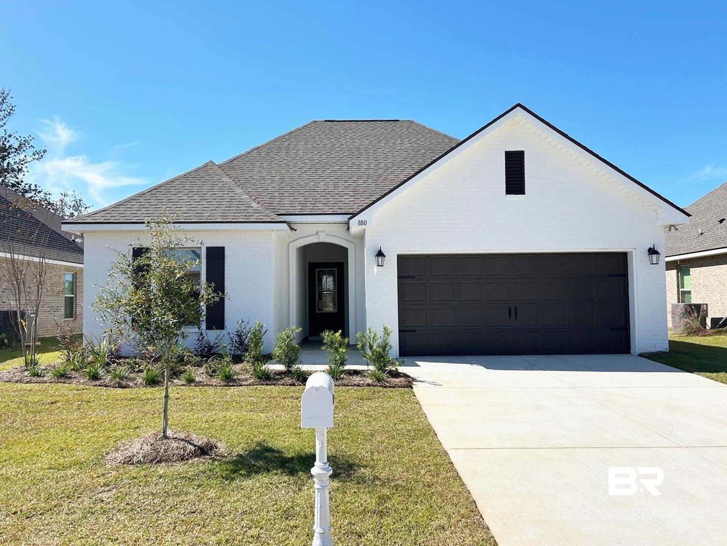 View of front facade featuring a front lawn and a garage
