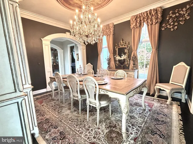 a living room with furniture a fireplace and a chandelier