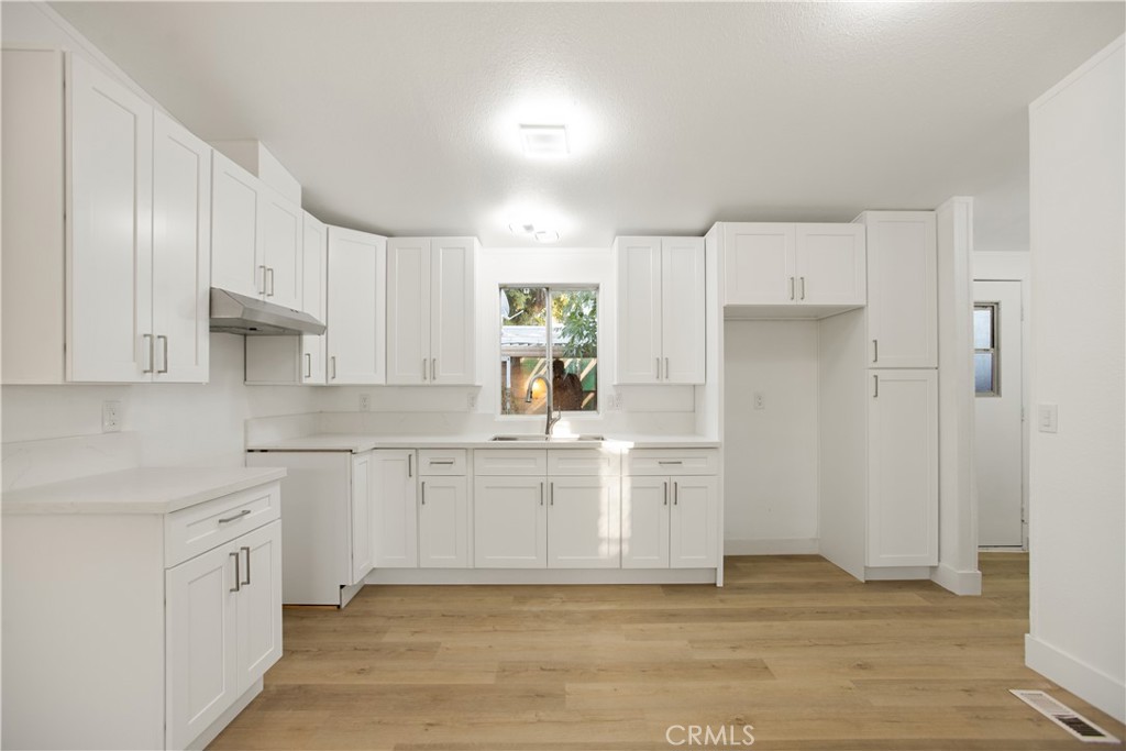 10350 Base Line Road, Unit 128 Rancho Cucamonga, CA 91701 - Photo 12 of 24 a kitchen with kitchen island white cabinets and refrigerator