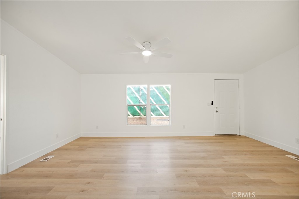 10350 Base Line Road, Unit 128 Rancho Cucamonga, CA 91701 - Photo 13 of 24 an empty room with wooden floor and windows