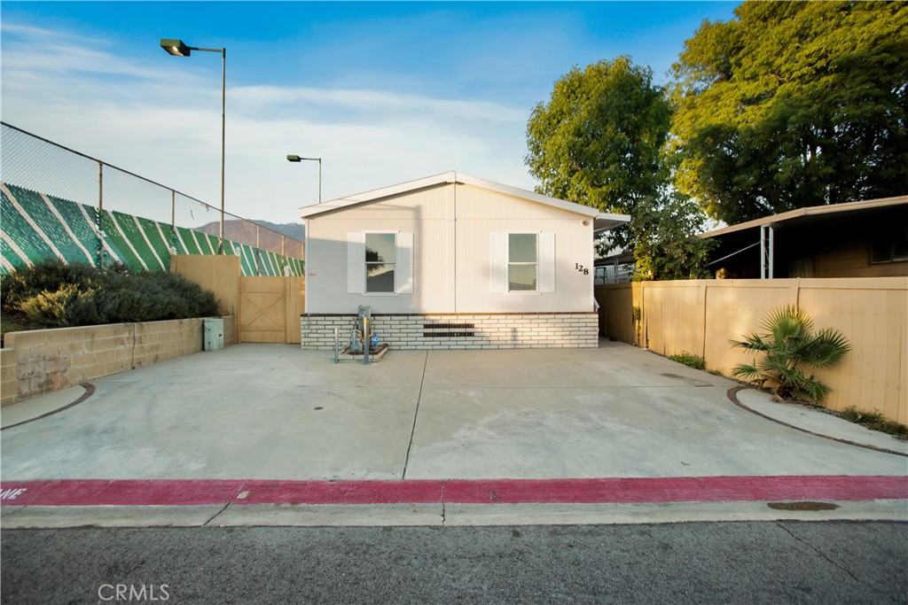 10350 Base Line Road, Unit 128 Rancho Cucamonga, CA 91701 - Photo 2 of 24 a white and red and white house with a white fence