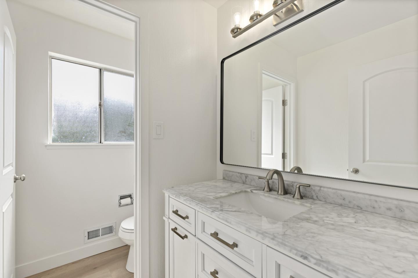 1238 Steven Drive Pittsburg, CA 94565 - Photo 24 of 39 a bathroom with a granite countertop sink a toilet and a mirror