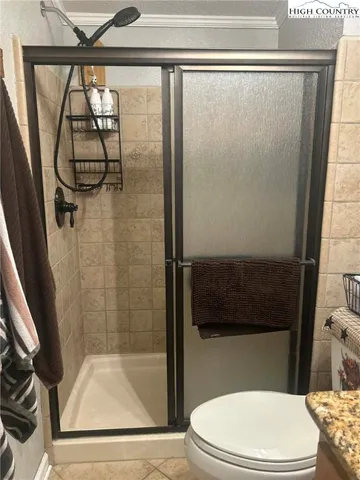 a bathroom with a granite countertop sink a mirror and shower