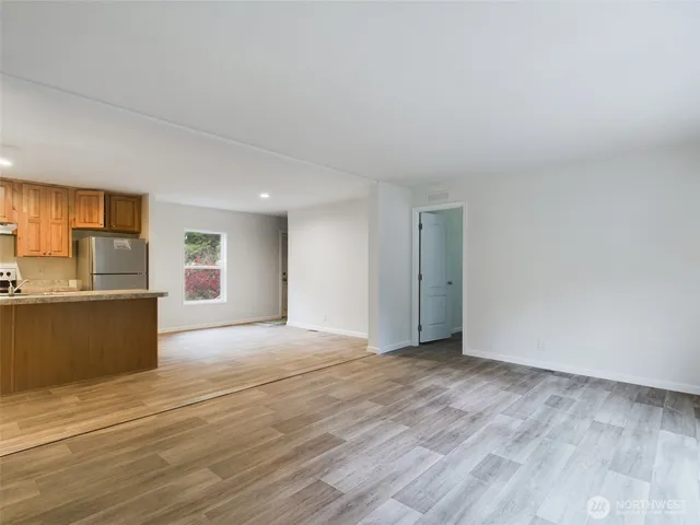 a view of kitchen with granite countertop cabinets and refrigerator