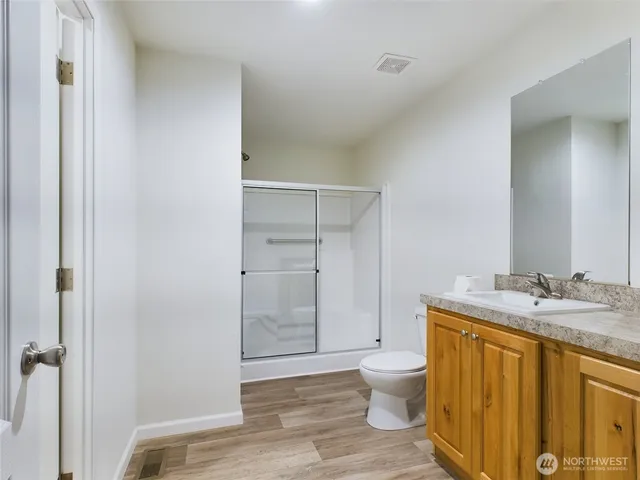 a bathroom with a granite countertop sink toilet a mirror and shower