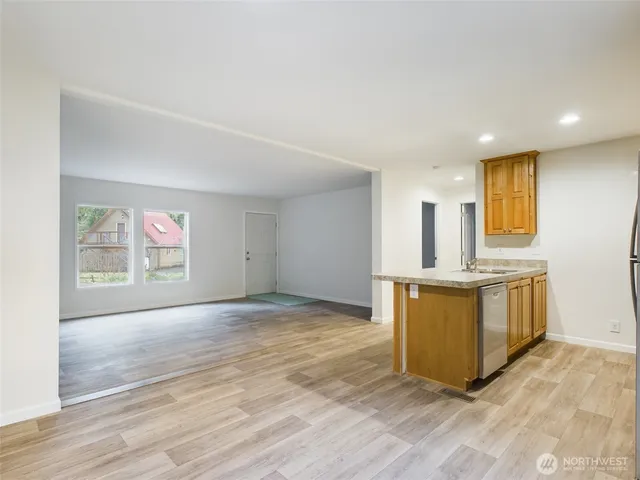 a view of kitchen with stainless steel appliances granite countertop a stove top oven a sink and a refrigerator