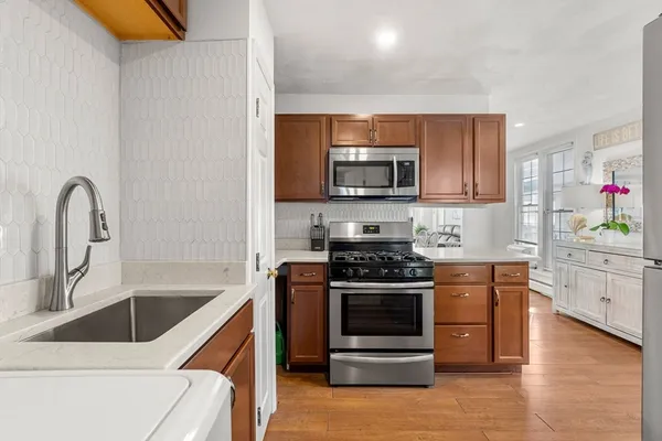 a kitchen with furniture wooden floor and a view of living room