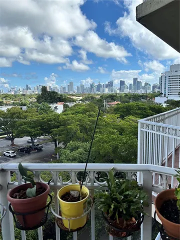 a view of a swimming pool with lawn chairs and potted plants