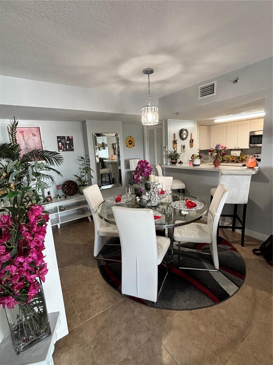 1650 Coral Way, Unit 808 Miami, FL 33145 - Photo 18 of 29 a view of a dining room with furniture and a chandelier