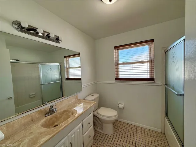 a room with a wooden floor and windows