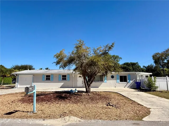 a backyard of a house with table and chairs