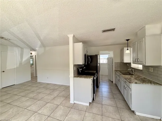 a kitchen with a sink stove and refrigerator